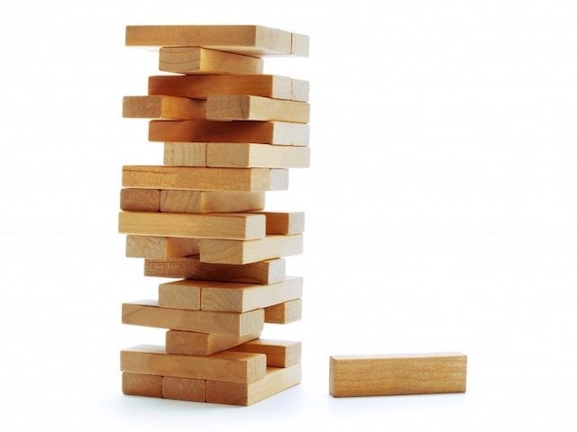 A stack of Jenga blocks, with one block laid to the side.