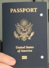 Navy blue passport with two hole punches in it.