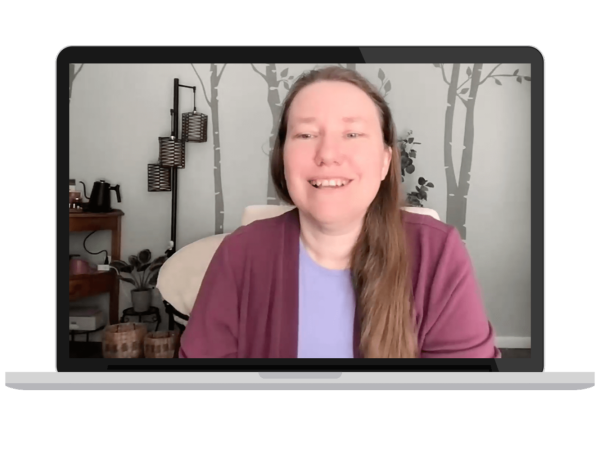 A laptop screen showing an image of a pale skinned woman talking to the camera.