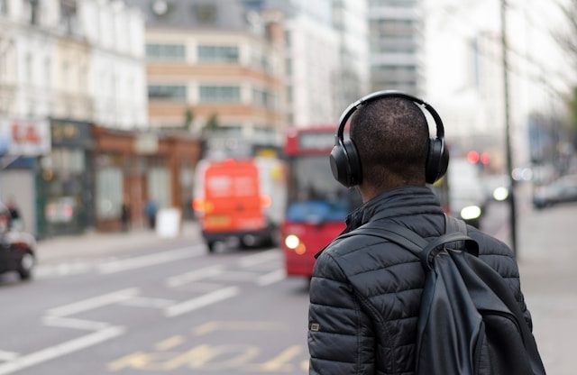 Person wearing headphones near a crosswalk.