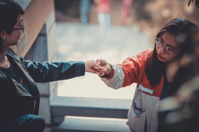 Two people in jackets holding hands.